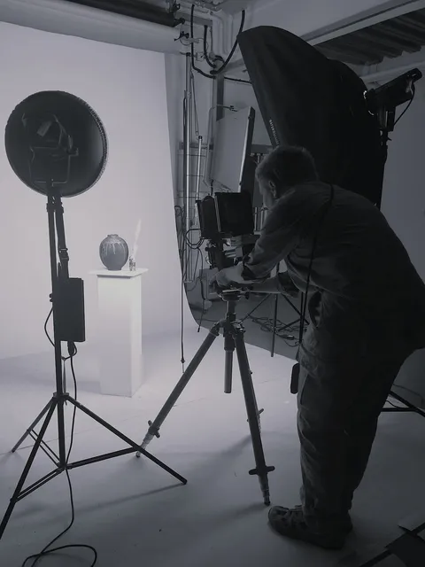 Daniel taking a photo of a pottery piece